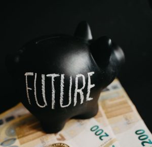 Black piggy bank labeled 'Future' with 200 euro bills and Bitcoin coins, symbolizing modern savings.
